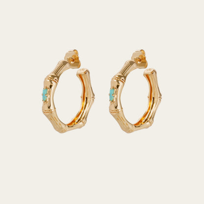 Gold hoop earrings with turquoise stones on a white background