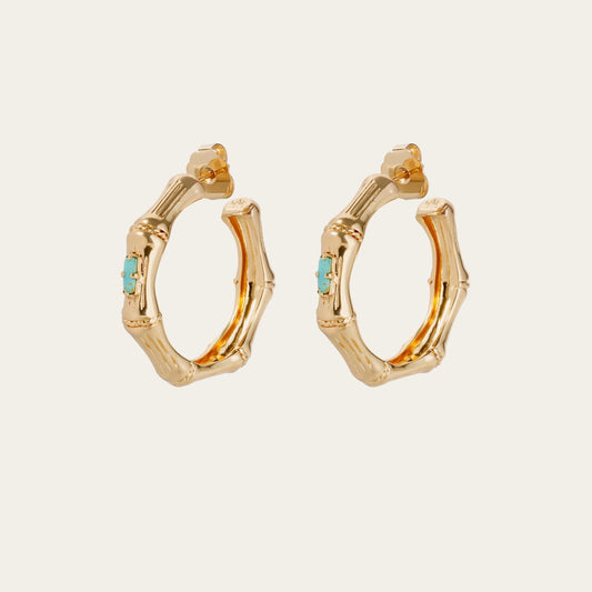 Gold hoop earrings with turquoise stones on a white background