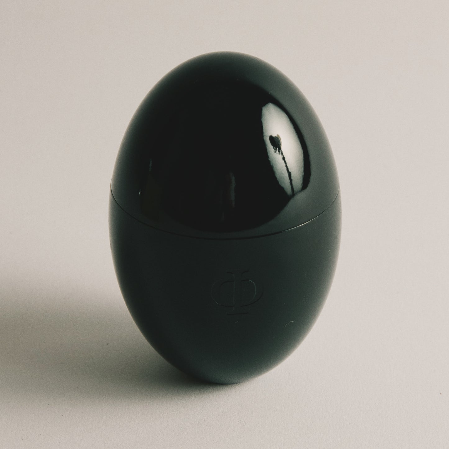 Black egg-shaped container on a light gray background
