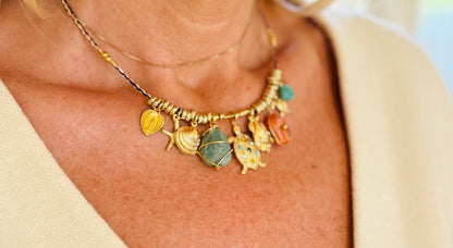 Necklace with various charms worn by a person