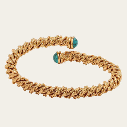 Gold bracelet with turquoise beads on a white background