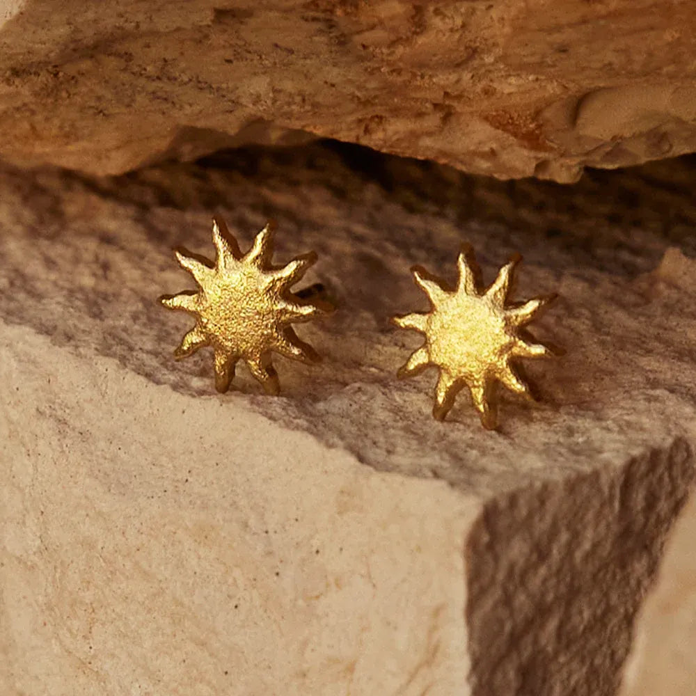 Sun gold studs on rocky background