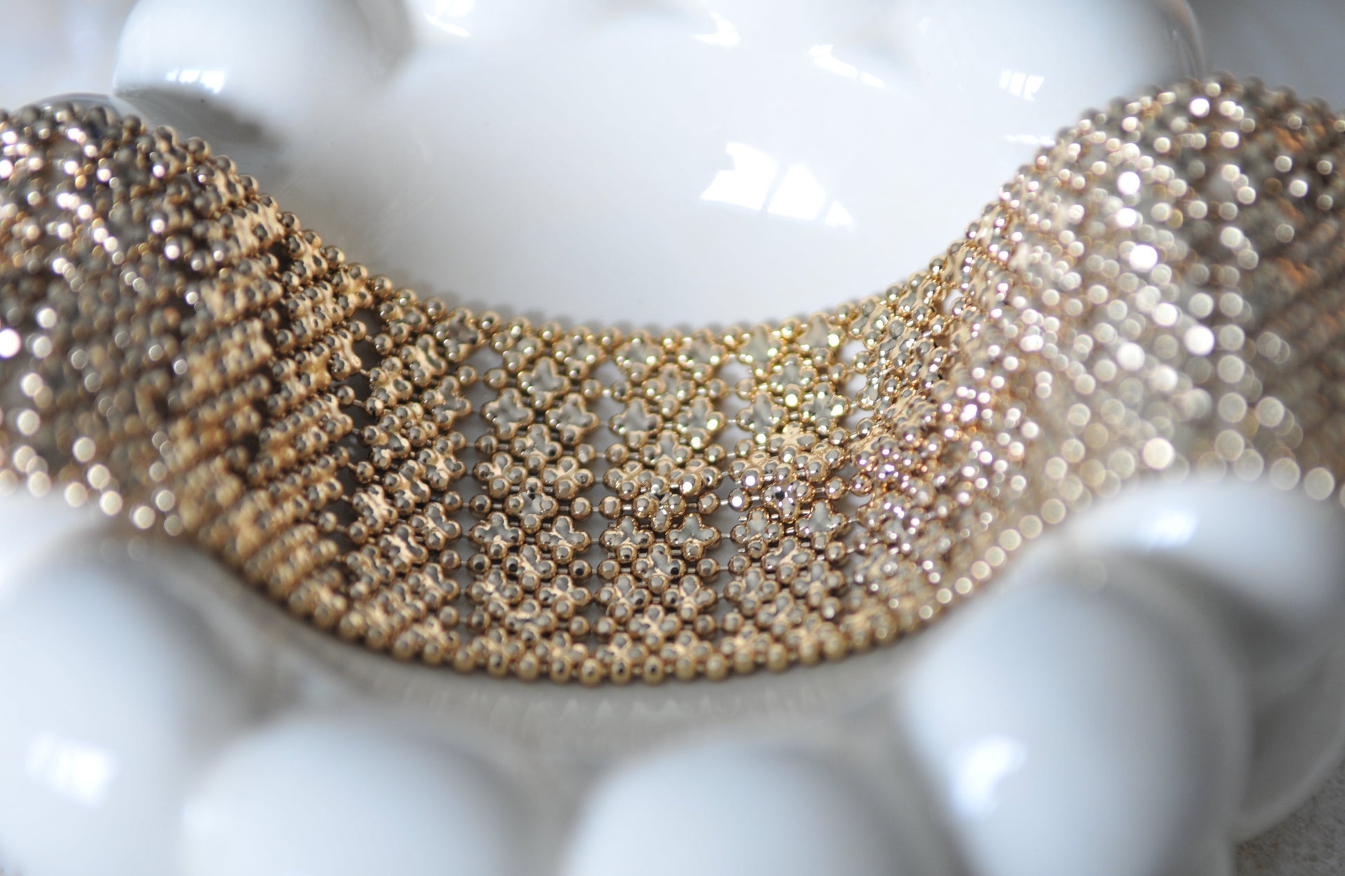 Gold beaded bracelet on a white surface