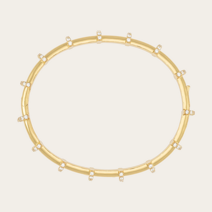 Gold bracelet with small diamonds on a white background