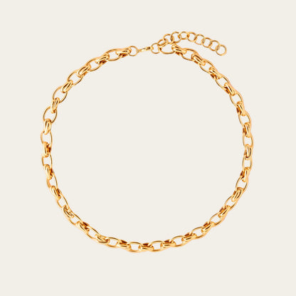 Gold chain bracelet on a beige background