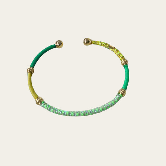 Green & Yellow threaded bracelet on light grey surface