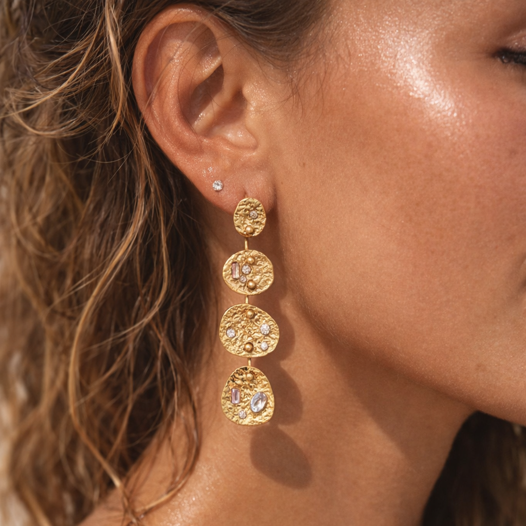 Close-up of a person wearing gold earrings with a blurred background