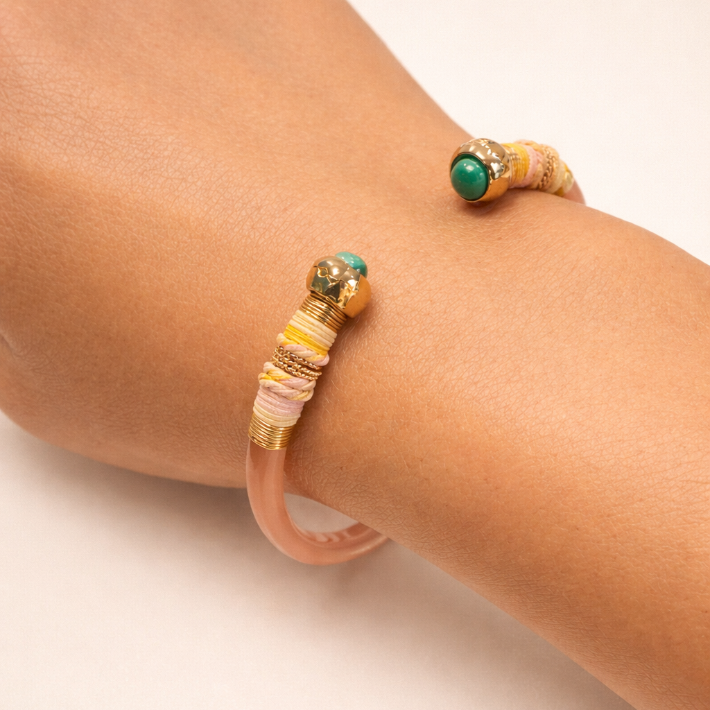 Two beaded bracelets on a person's wrist against a neutral background
