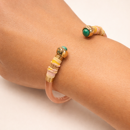 Two beaded bracelets on a person's wrist against a neutral background