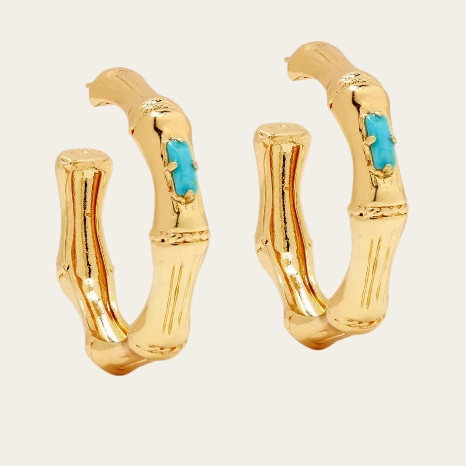 Gold hoop earrings with turquoise stones on a white background