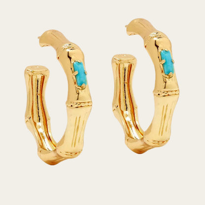 Gold hoop earrings with turquoise stones on a white background