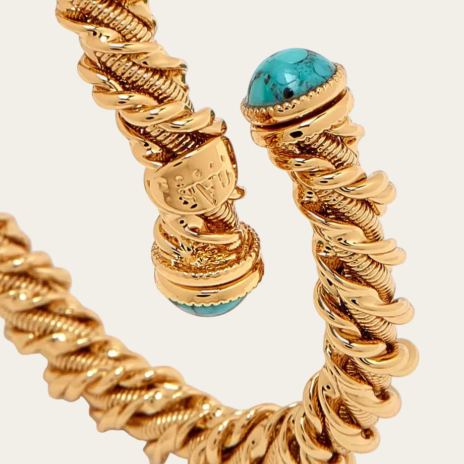 Gold bracelet with turquoise stones on a white background