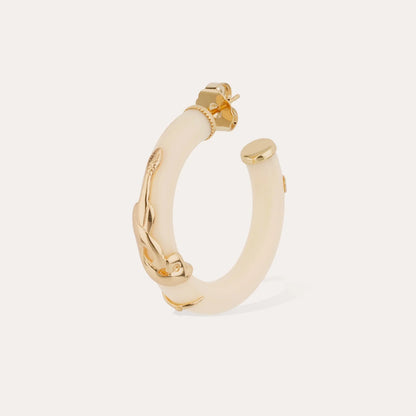 Gold hoop earring with a white center on a light beige background
