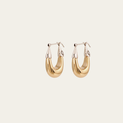 Gold hoop earrings on a light beige background