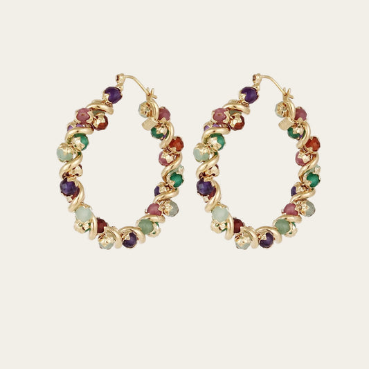 colourful stones on gold plated hoop earrings on a light background
