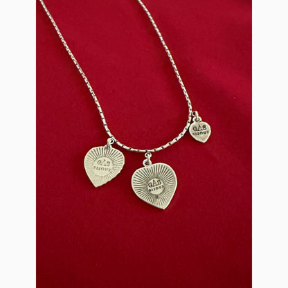 Silver bracelet with heart-shaped charms on a red background