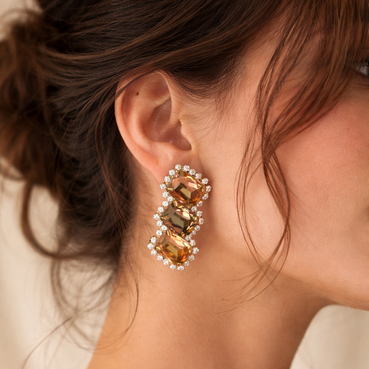 Close-up of a woman wearing elegant earrings with a neutral background