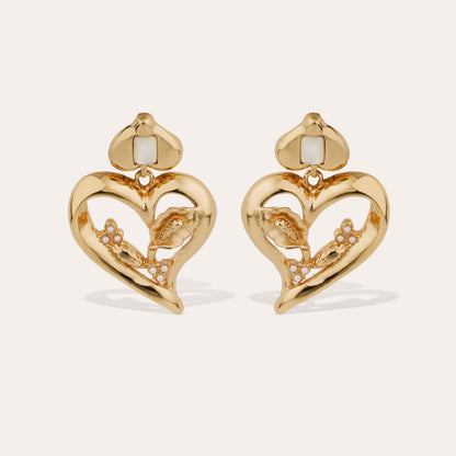 Gold love heart statement earrings with mother of pearl stones intertwined on cream background