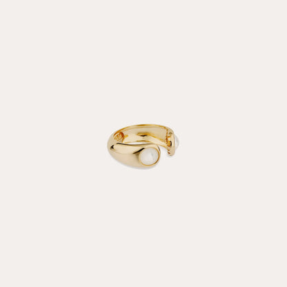 image of gold ring with two white mother of pearl stones at each end on cream background