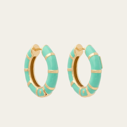 Turquoise hoop earrings with gold accents on a white background