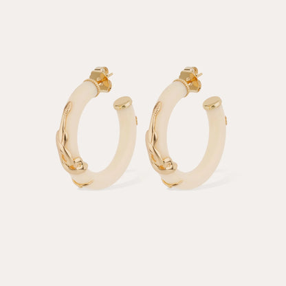 Pair of gold hoop earrings with beige accents on a light gray background