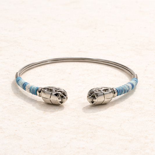 Silver bracelet with blue accents on a beige background