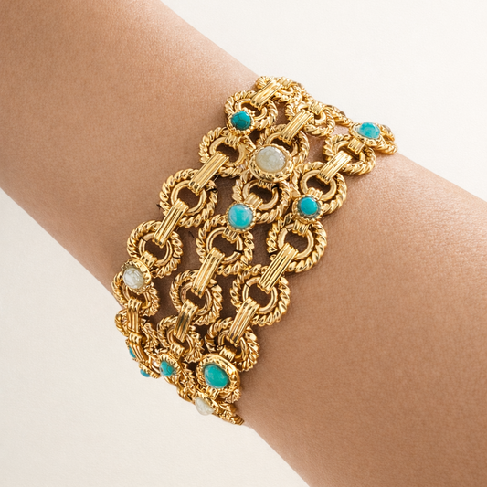 Gold bracelet with turquoise stones on a wrist against a white background