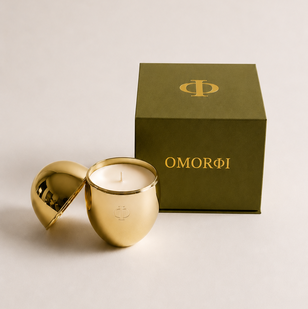 gold metallic candle along side green luxury gift box