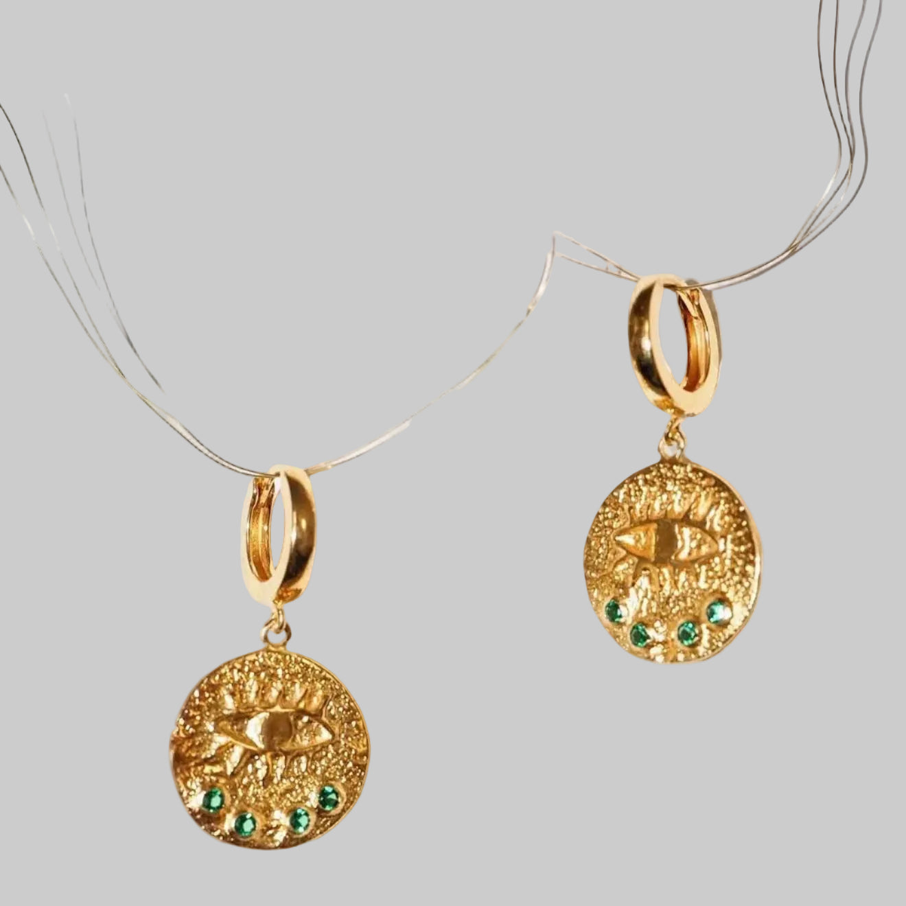 gold earrings with the eye and green stones on fishing wire