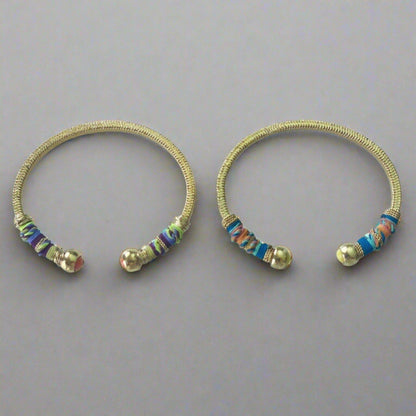 Gold plated bracelet embellished with tinted threads and gold plated chains.  The bracelet is adorned with glass beads at ends. Adjustable size.  Product Details  Yellow Gold Plated Cotton Rope or all metal Width: 0,6 ; Circumference: 14,5 cm