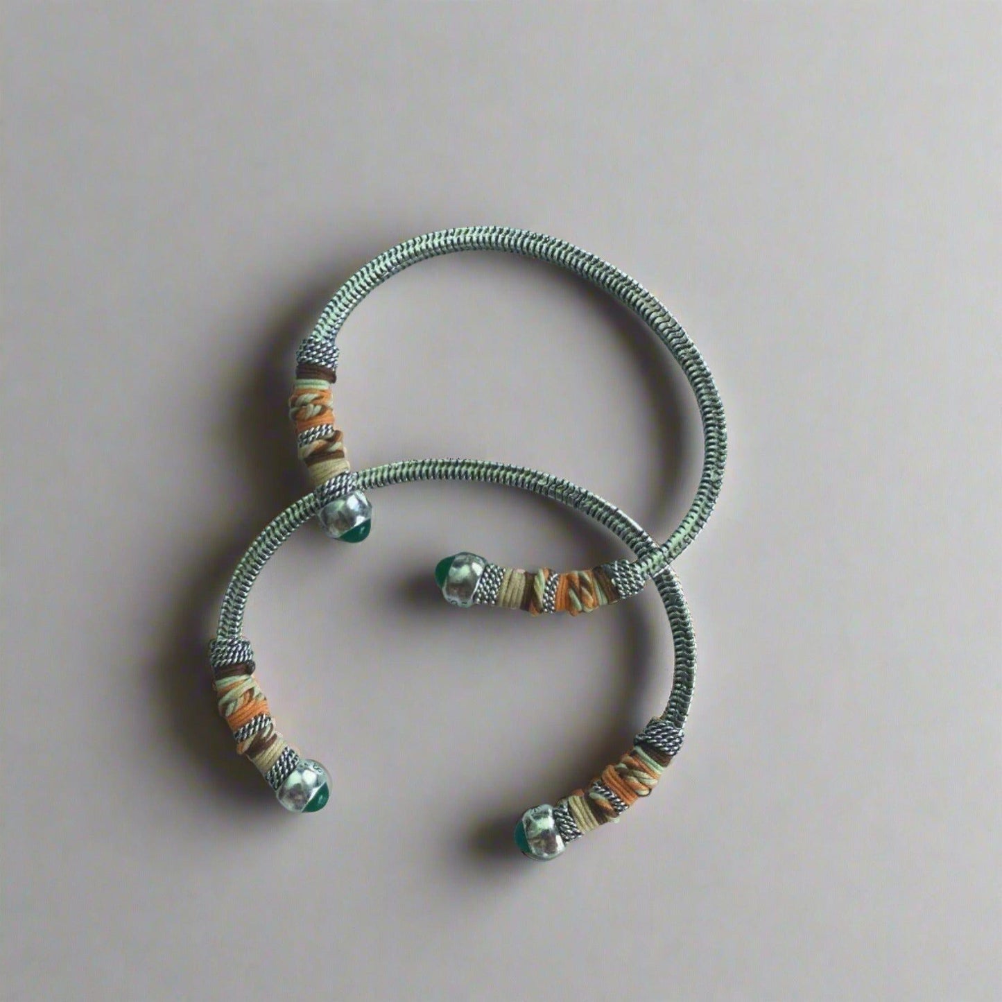 width of 0.7cms and a circumference of 16.5cms featuring two silver bangles on flat lay