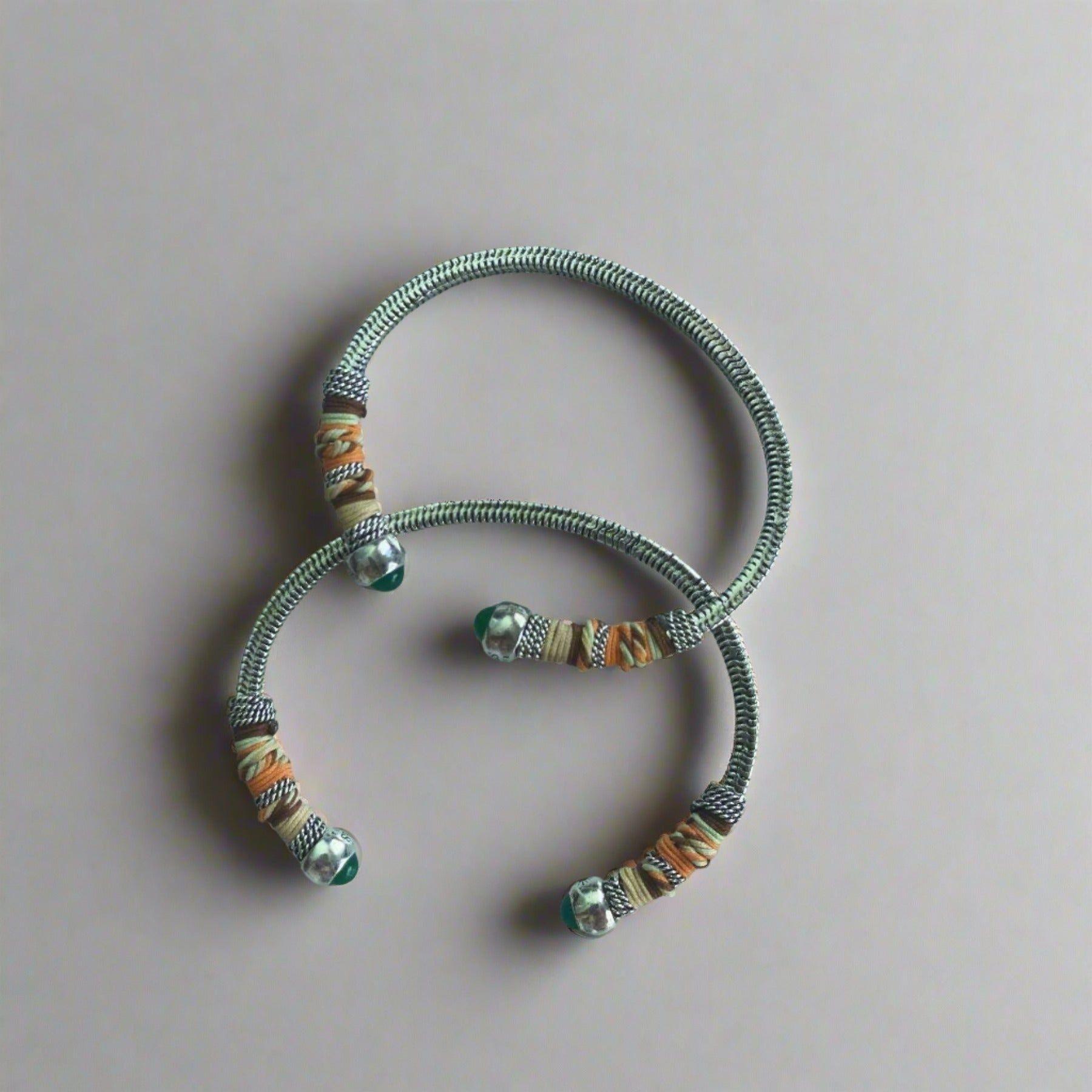 width of 0.7cms and a circumference of 16.5cms featuring two silver bangles on flat lay