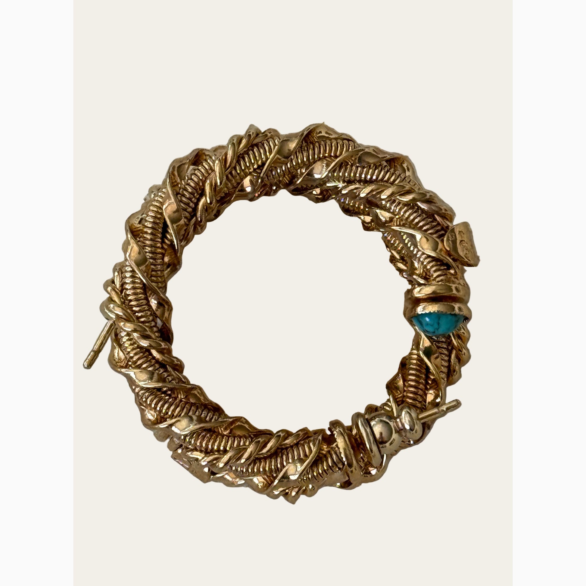 gold braided hoop earrings with turquoise stones on neutral background layered on top of eachother