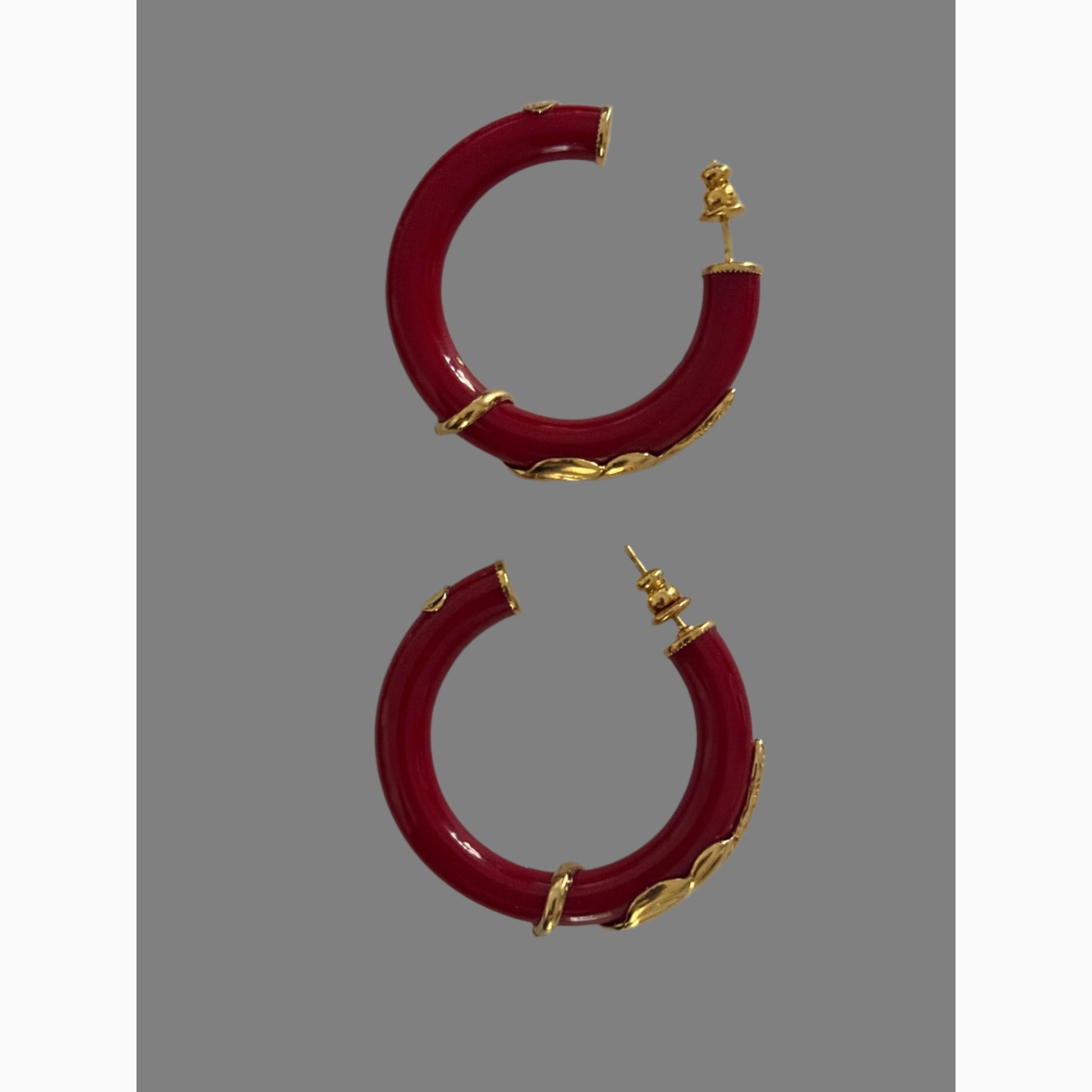 Red hoop earrings with gold accents on a white background