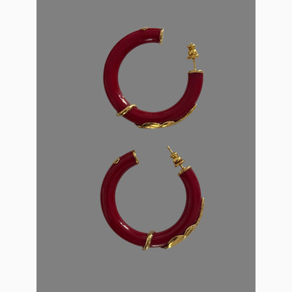 Red hoop earrings with gold accents on a white background