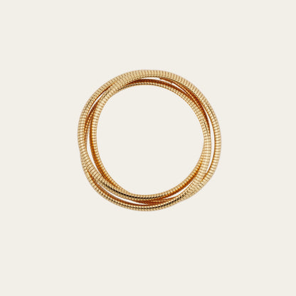 Set of gold bangles on a light beige background