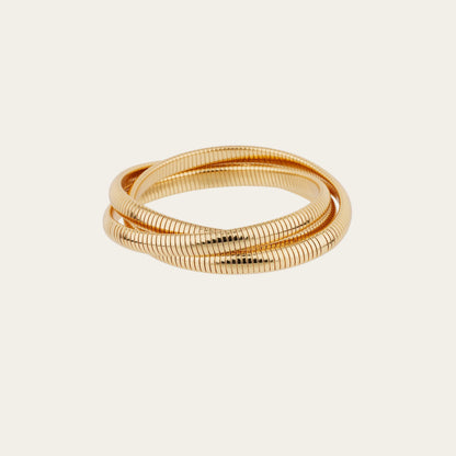 Gold bracelet with a textured design on a light beige background