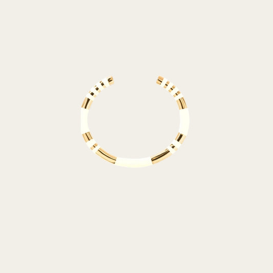 A white and gold bangle bracelet with a simple, elegant design featuring ivory stripes and gold accents.
