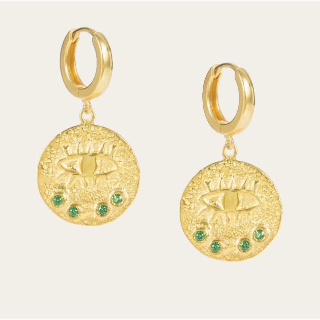 Gold hoop earrings with circular gold charms and green gemstones on a white background