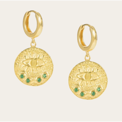 Gold hoop earrings with circular gold charms and green gemstones on a white background