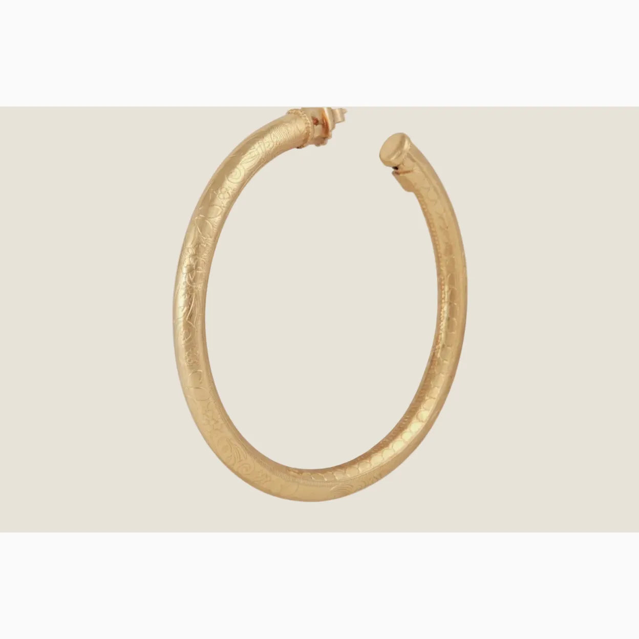 Gold hoop earring on a white background