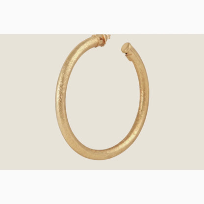 Gold hoop earring on a white background