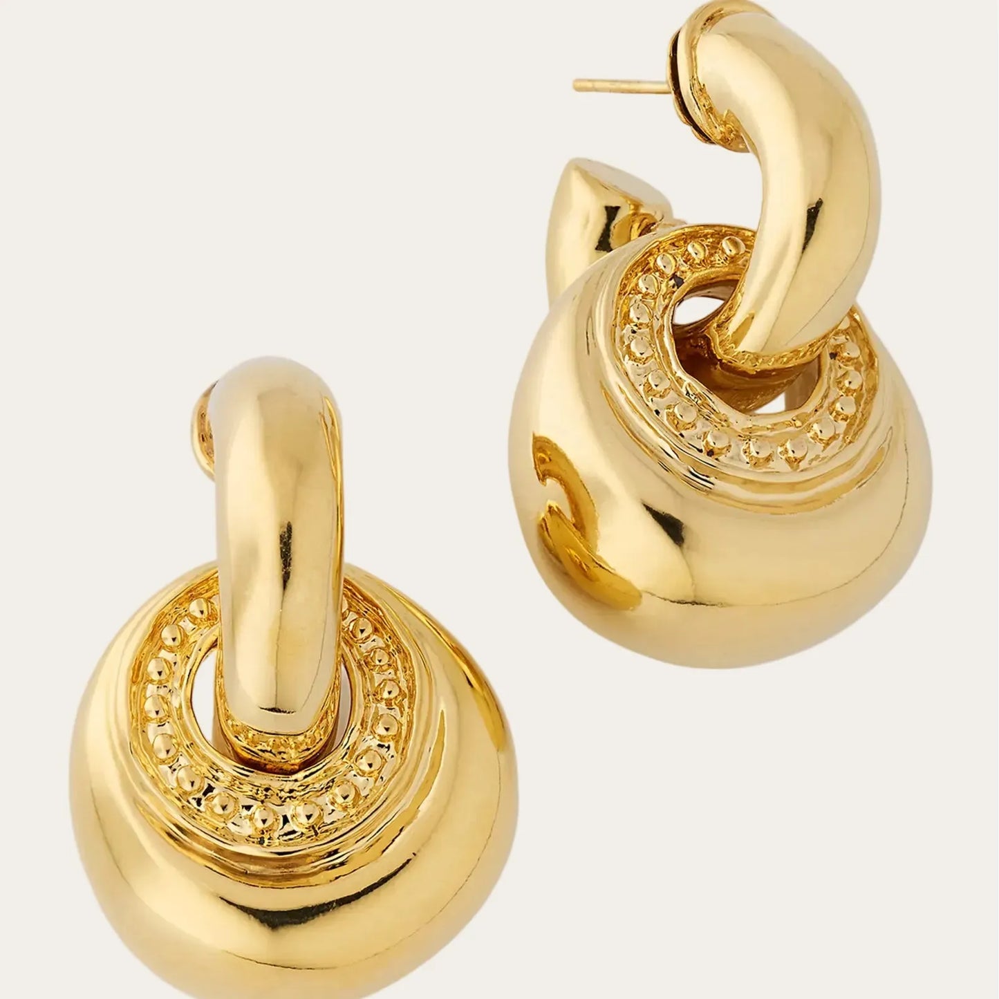 Gold hoop earrings on a light gray background