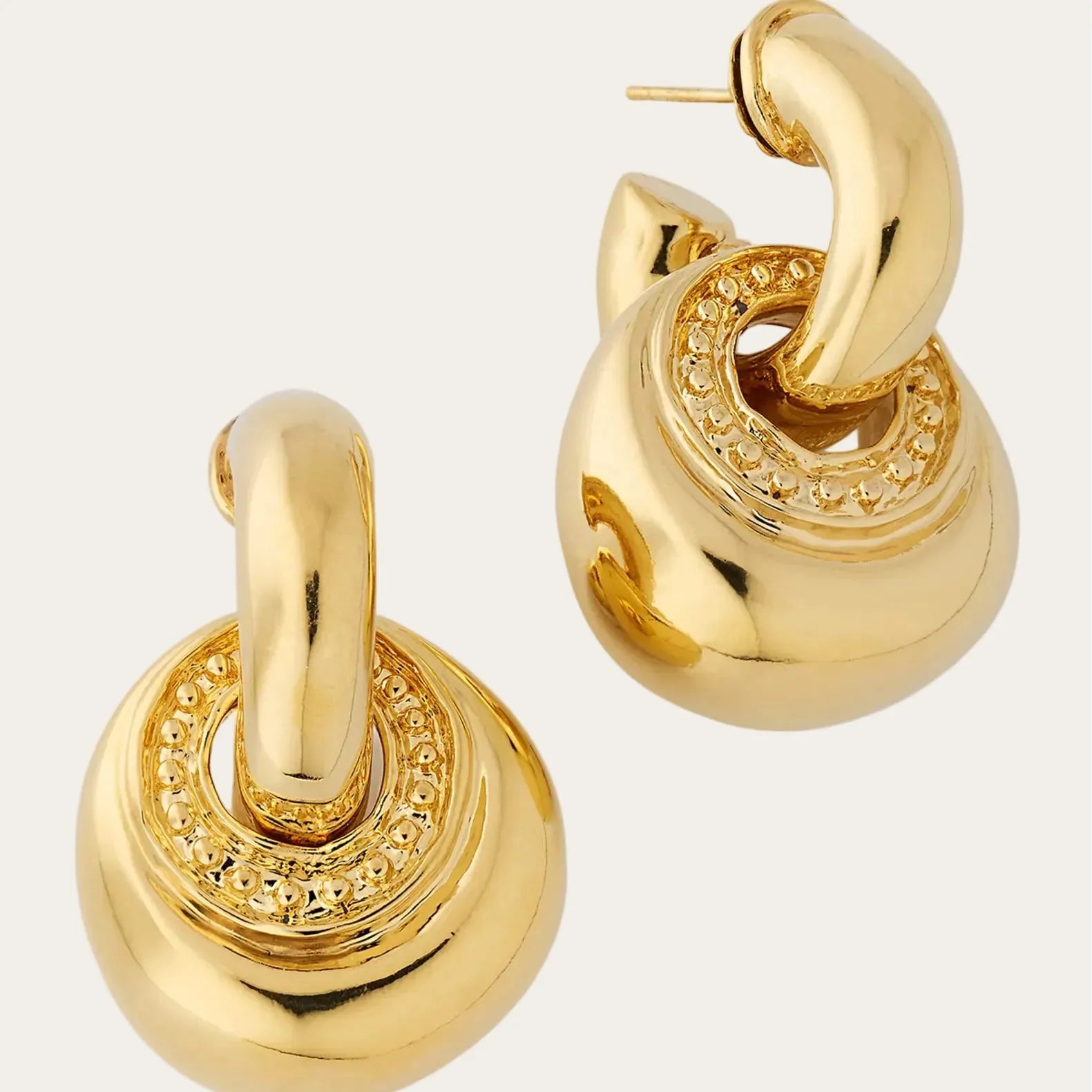 Gold hoop earrings on a light gray background
