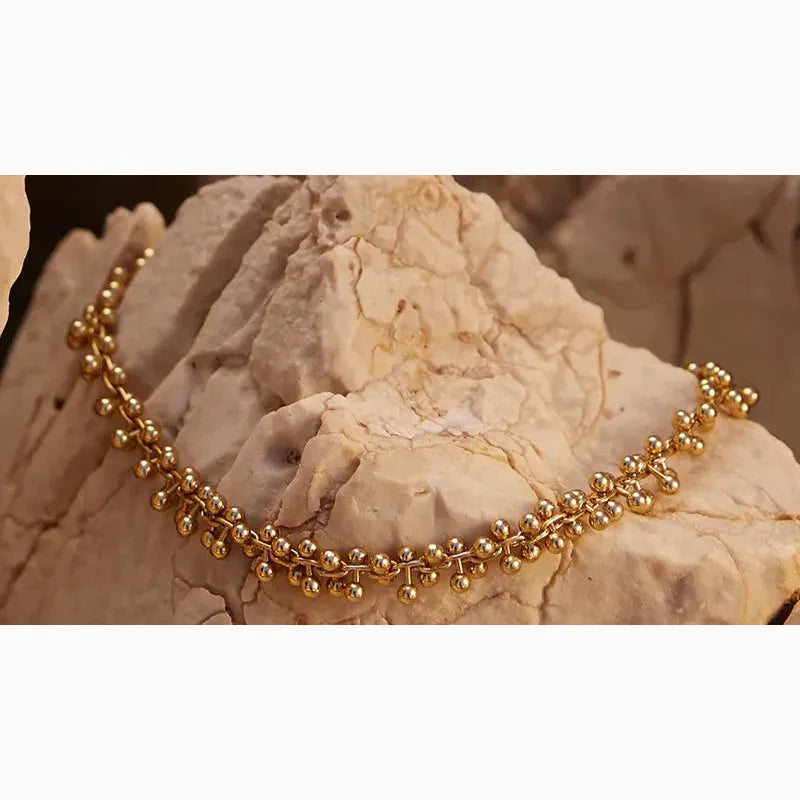gold bracelet on marble stone backdrop