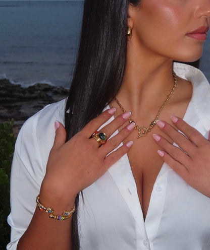 Woman wearing gold jewelry with a scenic background