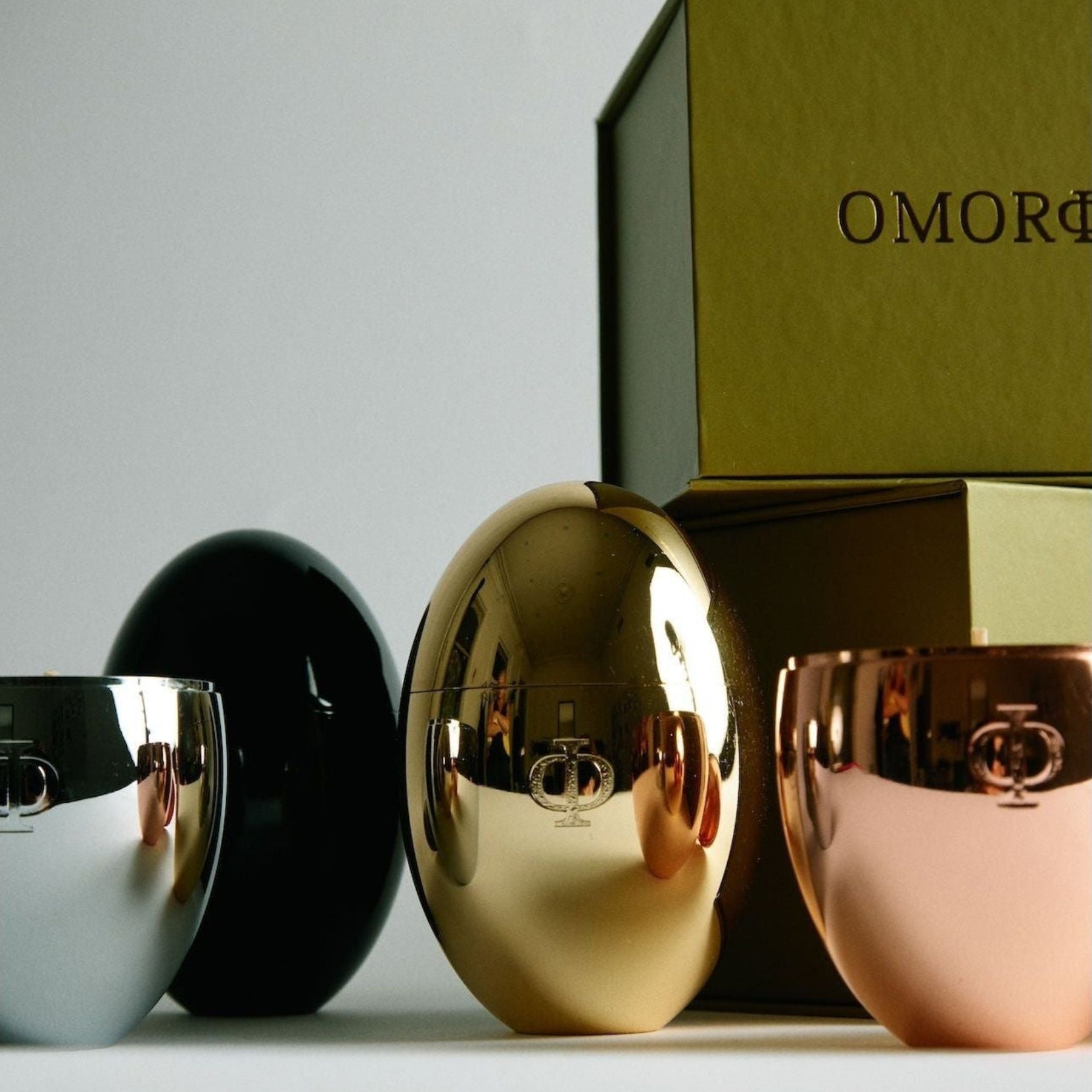 Silver, black, gold and rose gold egg shaped candles and luxury green gift box