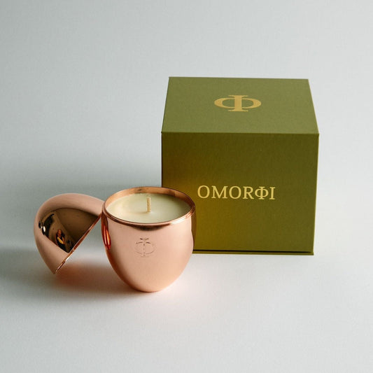 rose gold egg candle with olive green gift box beside it
