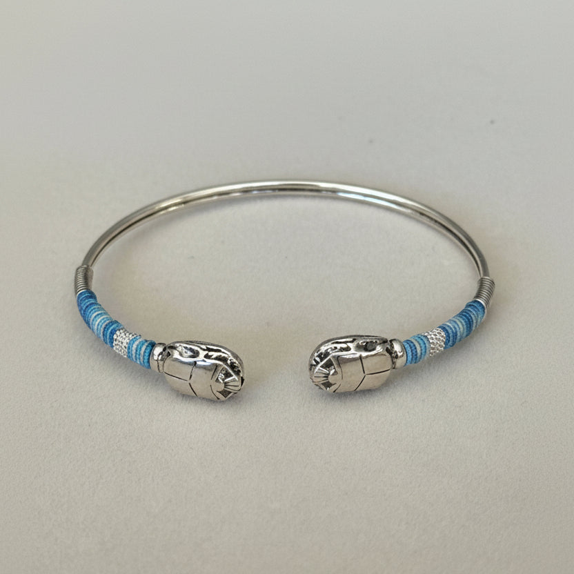 Silver bracelet with blue accents on a light gray background