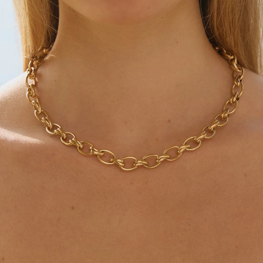 Gold chain necklace on a person with a blurred background